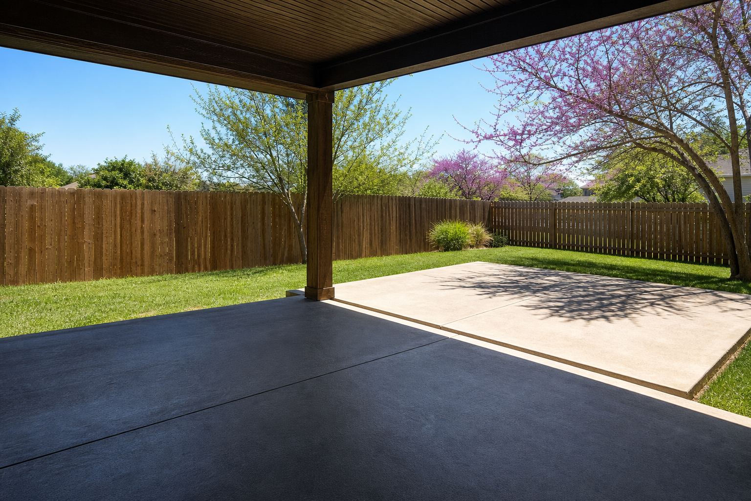 Empty covered patio opening onto a sunlit concrete pad